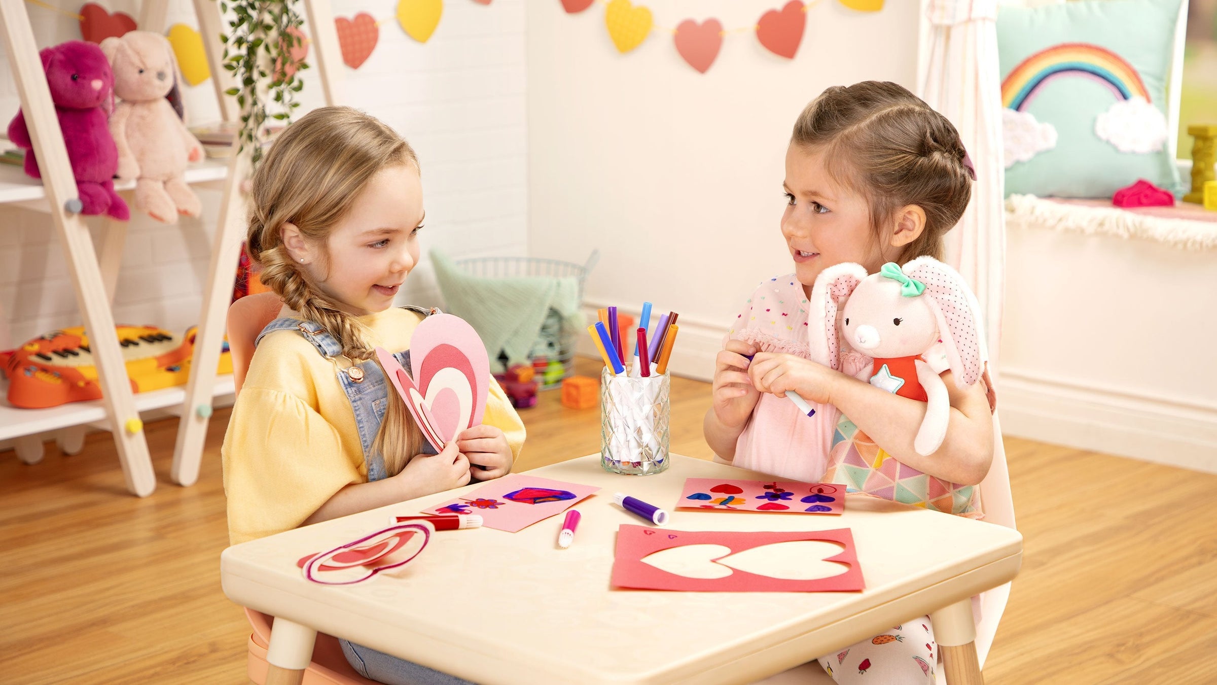 little girls drawing on cards and playing with dolls